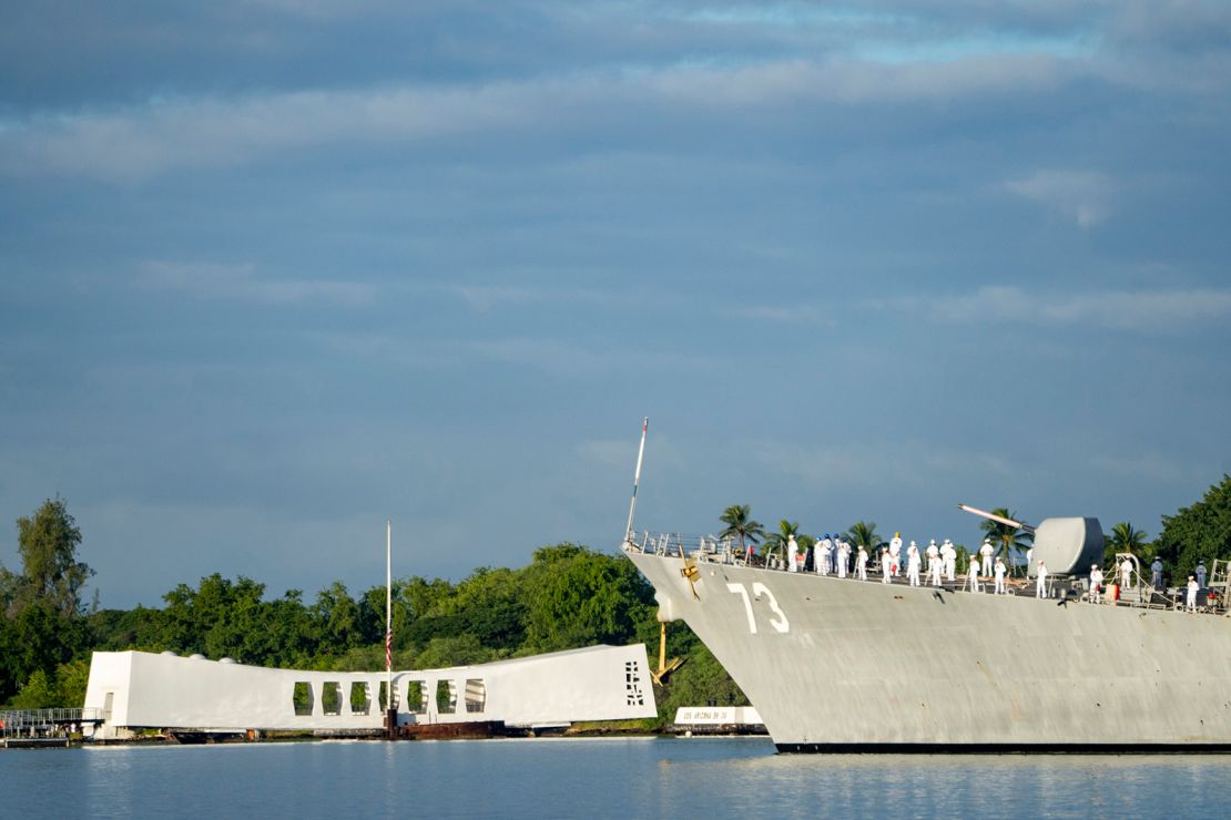 Marynarze na pokładzie USS Decatur oddają honory podczas mijania pomnika USS Arizona i zatopionego pancernika USS Arizona podczas 82. ceremonii z okazji Dnia Pamięci o Pearl Harbor w czwartek, 7 grudnia 2023 r. w Pearl Harbor w Honolulu na Hawajach.