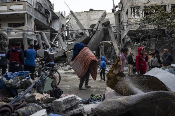 Palestyńczycy sprawdzają zniszczenia budynków mieszkalnych po izraelskim nalocie w Rafah w południowej Strefie Gazy, niedziela, 24 marca 2024 r. (AP Photo/Fatima Shbair)