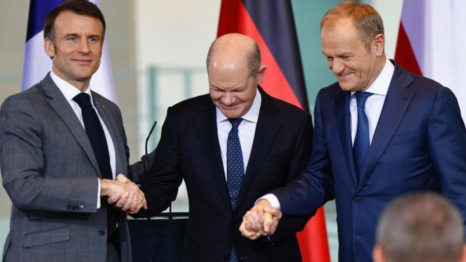 (LR) Prezydent Francji Emmanuel Macron, kanclerz Niemiec Olaf Scholz i premier Polski Donald Tusk podają sobie dłonie po konferencji prasowej w Kancelarii w Berlinie