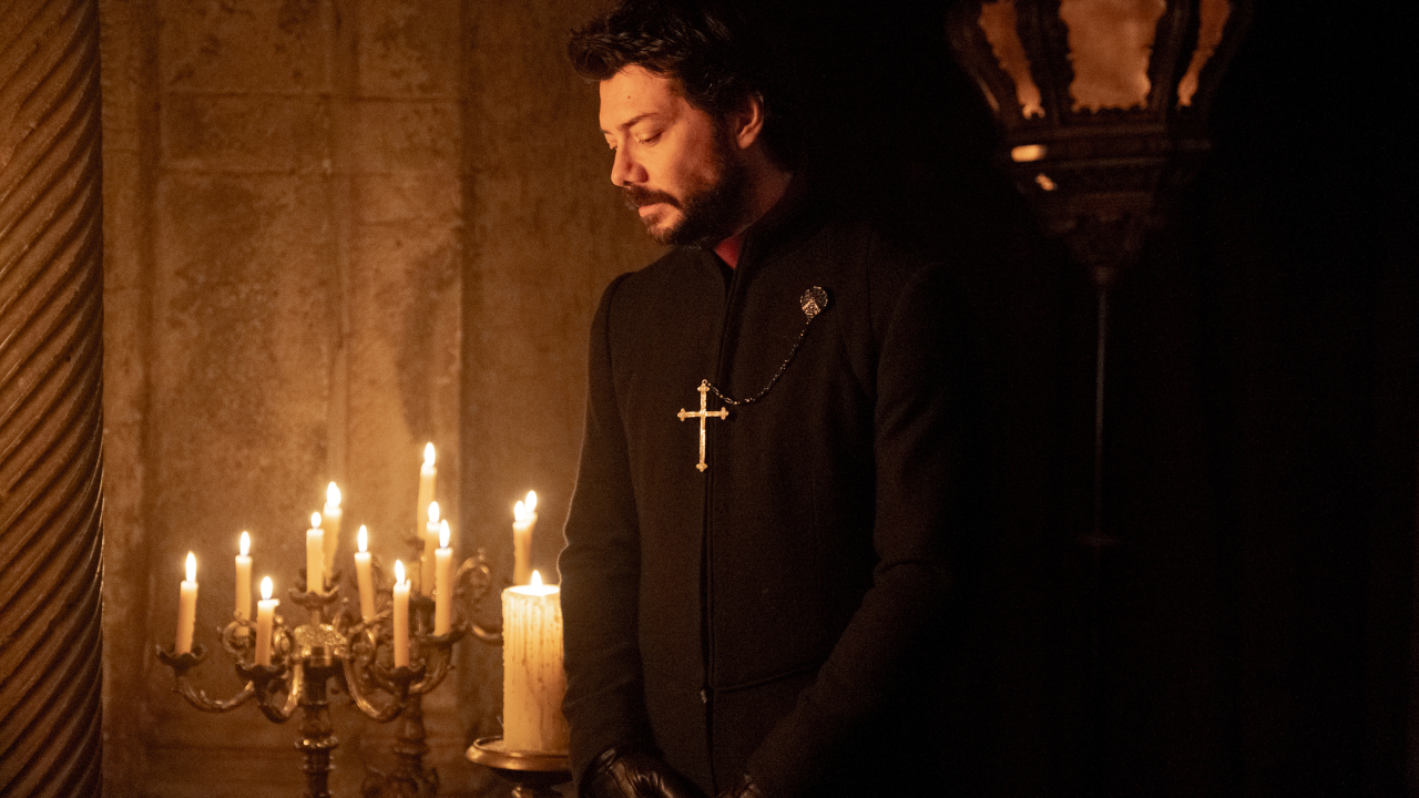 Álvaro Morte stoi z czcią obok zapalonej świecy w ciemności w Niepokalanej.