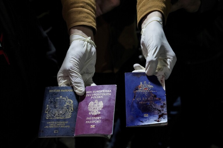 Mężczyzna pokazuje zakrwawione paszporty brytyjskie, polskie i australijskie po izraelskim nalocie, w Deir al-Balah, Strefa Gazy, poniedziałek, 1 kwietnia 2024 r. (AP Photo/Abdel Kareem Hana)