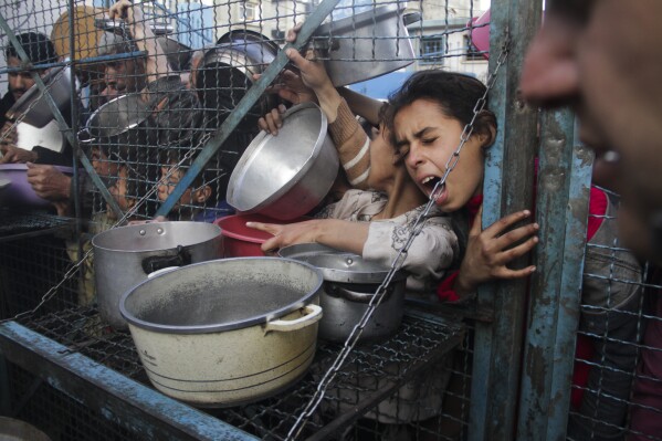PLIK – Palestyńczycy ustawiają się w kolejce po bezpłatne posiłki w obozie dla uchodźców Jabaliya w Strefie Gazy 18 marca 2024 r. (AP Photo/Mahmoud Essa, plik)