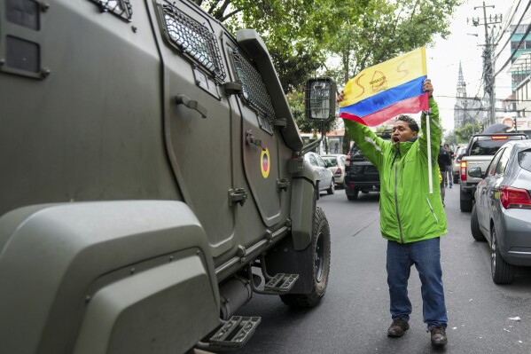 Zwolennik byłego wiceprezydenta Ekwadoru Jorge Glasa protestuje, gdy pojazd wojskowy transportuje go z aresztu, w którym był przetrzymywany po aresztowaniu w ambasadzie Meksyku w Quito, Ekwador, sobota, 6 kwietnia 2024 r. Glas, który był wiceprezydentem Ekwadoru w latach 2013–2018, skazany za korupcję i od grudnia ukrywa się w ambasadzie.  (AP Photo/Dolores Ochoa)