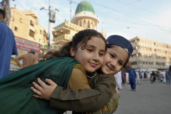 Muzułmańskie dzieci witają się z okazji Eid po wzięciu udziału w modlitwie Eid al-Fitr, kończącej miesiąc postu Ramadan w Karaczi w Pakistanie, środa, 10 kwietnia 2024 r. (AP Photo/Fareed Khan)