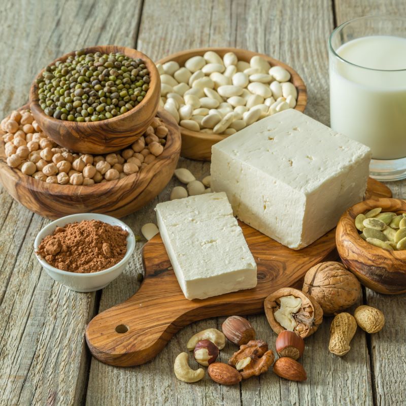 Różnorodne białka roślinne w miskach, w tym tofu, soczewica, ciecierzyca i orzechy. 
