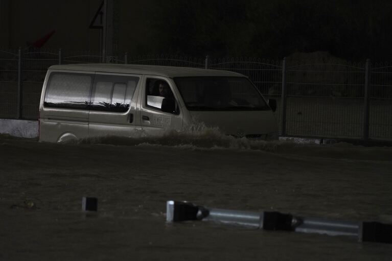 Furgonetka przejeżdża przez stojącą wodę w Dubaju w Zjednoczonych Emiratach Arabskich, wtorek, 16 kwietnia 2024 r. We wtorek Zjednoczone Emiraty Arabskie nawiedziły ulewne deszcze, zalewając fragmenty głównych autostrad i pozostawiając pojazdy porzucone na drogach w całym Dubaju.  W międzyczasie liczba ofiar śmiertelnych w wyniku osobnych, silnych powodzi w sąsiednim Omanie wzrosła do 18, a inne osoby nadal są zaginione, podczas gdy sułtanat przygotowywał się na burzę.  (AP Photo/Jon Gambrell)