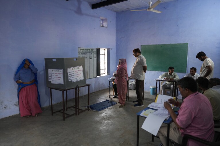 Ludzie głosują podczas pierwszej tury głosowania w wyborach krajowych w Indiach w Neemrana w stanie Radżastan w Indiach, piątek, 19 kwietnia 2024 r. Prawie 970 milionów wyborców wybierze 543 członków do izby niższej parlamentu na pięć lat podczas rozłożonych w czasie wyborów, które odbędą się trwać do 1 czerwca. (AP Photo/Manish Swarup)