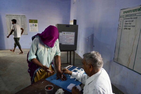 Kobieta przygotowuje się do głosowania podczas pierwszej tury głosowania w wyborach krajowych w Indiach w Neemrana w stanie Radżastan w Indiach, piątek, 19 kwietnia 2024 r. Prawie 970 milionów wyborców wybierze 543 członków do izby niższej parlamentu na pięć lat, w czasie rozłożonym w czasie wybory, które potrwają do 1 czerwca. (AP Photo/Manish Swarup)