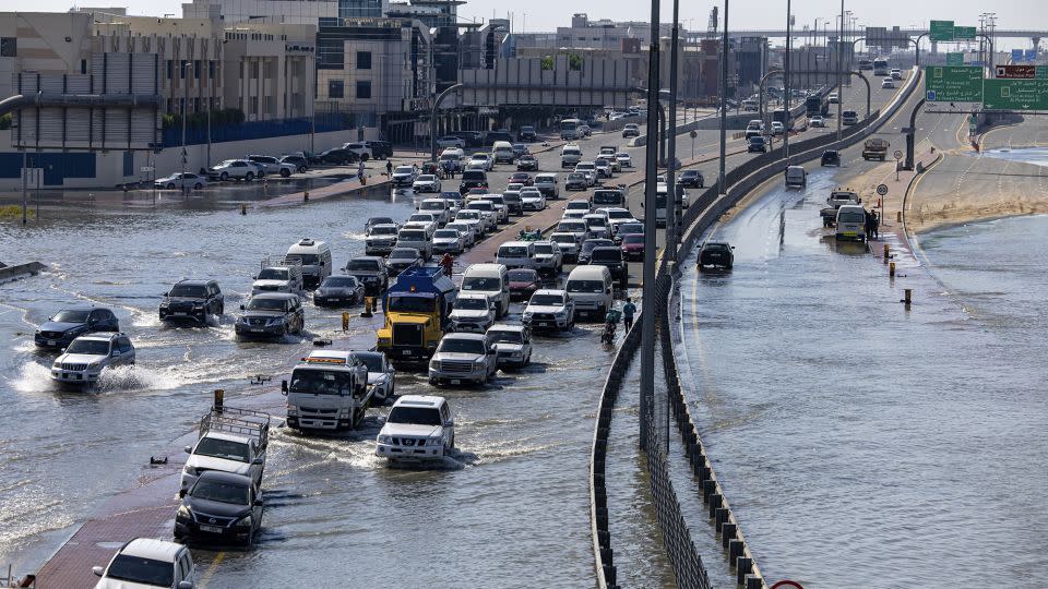 Pojazdy przejeżdżają przez wody powodziowe spowodowane ulewnymi deszczami w Dubaju w czwartek.  - Christopher Pike/AP