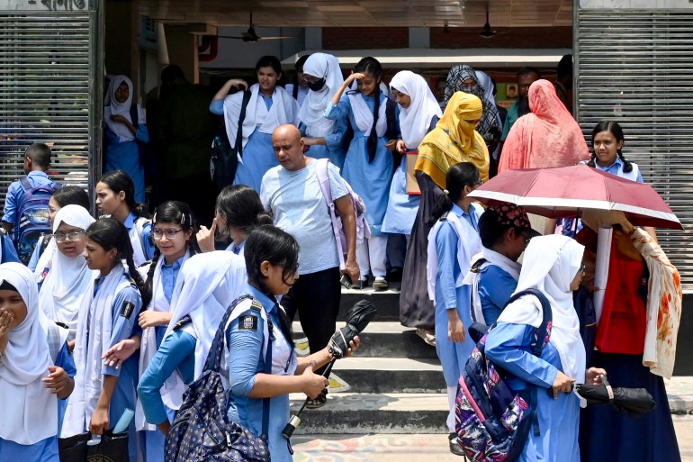 Uczniowie opuszczający teren szkoły noszą parasole w gorący letni dzień w Dhace, 28 kwietnia 2024 r., pośród trwającej fali upałów.  – 28 kwietnia miliony uczniów wróciło do ponownie otwartych szkół w całym Bangladeszu