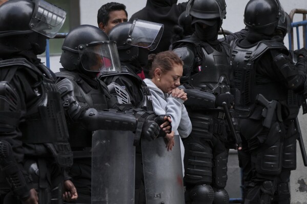 Zwolennik byłego wiceprezydenta Ekwadoru Jorge Glasa stoi przed aresztem, do którego został zabrany po włamaniu się policji do ambasady Meksyku, aby go aresztować, w Quito w Ekwadorze, sobota, 6 kwietnia 2024 r. Glas, który sprawował funkcję wiceprezydenta Ekwadoru w latach 2013–2018, skazany za korupcję i od grudnia ukrywa się w ambasadzie Meksyku.  (AP Photo/Dolores Ochoa)