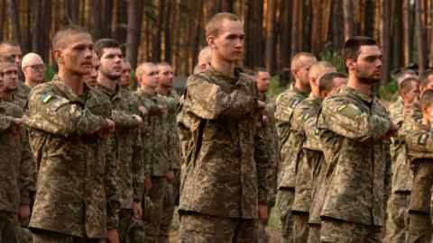 Nowo werbowani żołnierze 3. Brygady Szturmowej Ukrainy ustawiają się w bazie wojskowej niedaleko Kijowa