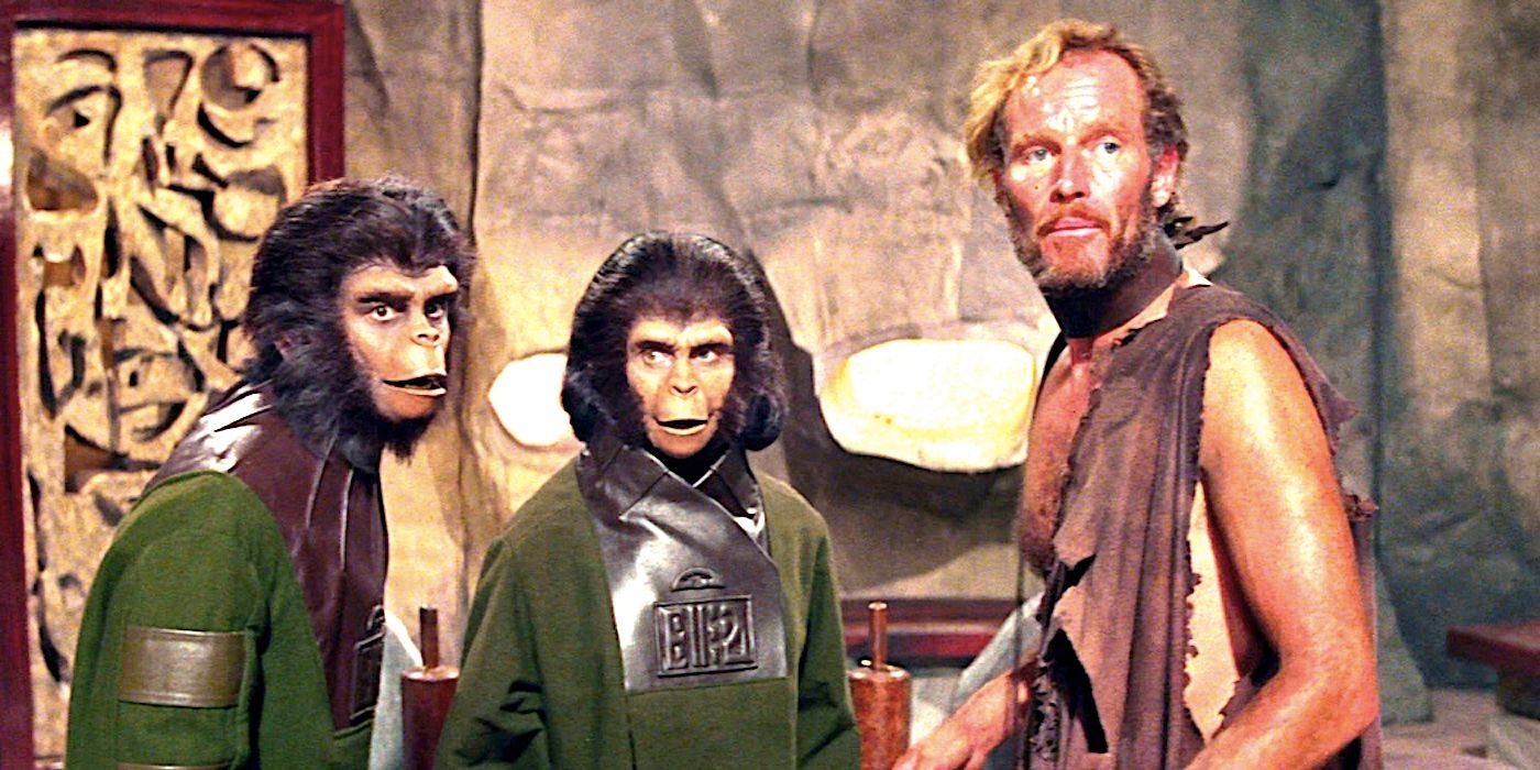 Zaniedbany George Charltona Hestona stoi obok dwóch małp w pomieszczeniu w Planet of the Apes 1968