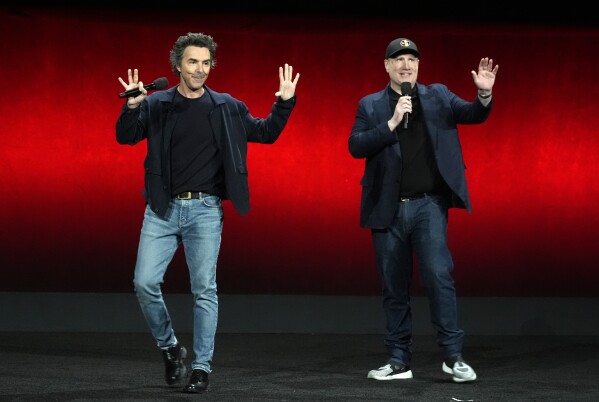 Shawn Levy (z lewej), reżyser nadchodzącego filmu "Deadpool i Wolverine," i prezes Marvel Studios, Kevin Feige, machają do publiczności podczas prezentacji Walt Disney Studios na CinemaCon 2024, czwartek, 11 kwietnia 2024 r. w Caesars Palace w Las Vegas.  (AP Photo/Chris Pizzello)