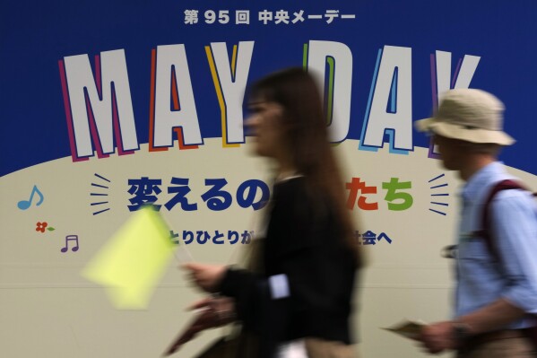 Ludzie idą w kierunku miejsca wiecu pierwszomajowego w Tokio, środa, 1 maja 2024 r. (AP Photo/Hiro Komae)