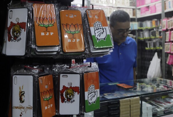 PLIK – Etui na telefony komórkowe przedstawiające symbole różnych partii politycznych wystawione w hurtowni w Bombaju w Indiach, 9 kwietnia 2019 r. W Internecie rośnie liczba dezinformacji na temat wyborów w Indiach, ponieważ głosuje w najludniejszym kraju na świecie.  Kraj ma ogromny ekosystem internetowy z największą liczbą użytkowników WhatsApp i YouTube na świecie. (AP Photo/Rajanish Kakade, plik)