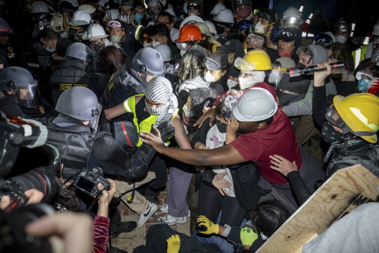 Policja atakuje propalestyńskich demonstrantów na kampusie UCLA, czwartek, 2 maja 2024 r. w Los Angeles.  (AP Photo/Ethan Swope)