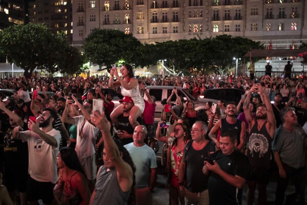 Performerka Rinnaldy Borba przebrana za Madonnę pozuje do selfie z fanem podczas próby przed trasą Madonna's Celebration w Rio de Janeiro w Brazylii, czwartek, 2 maja 2024 r. Madonna zakończy swoją trasę w sobotę bezpłatnym koncertem na plaży Copacabana .  (AP Photo/Bruna Prado)