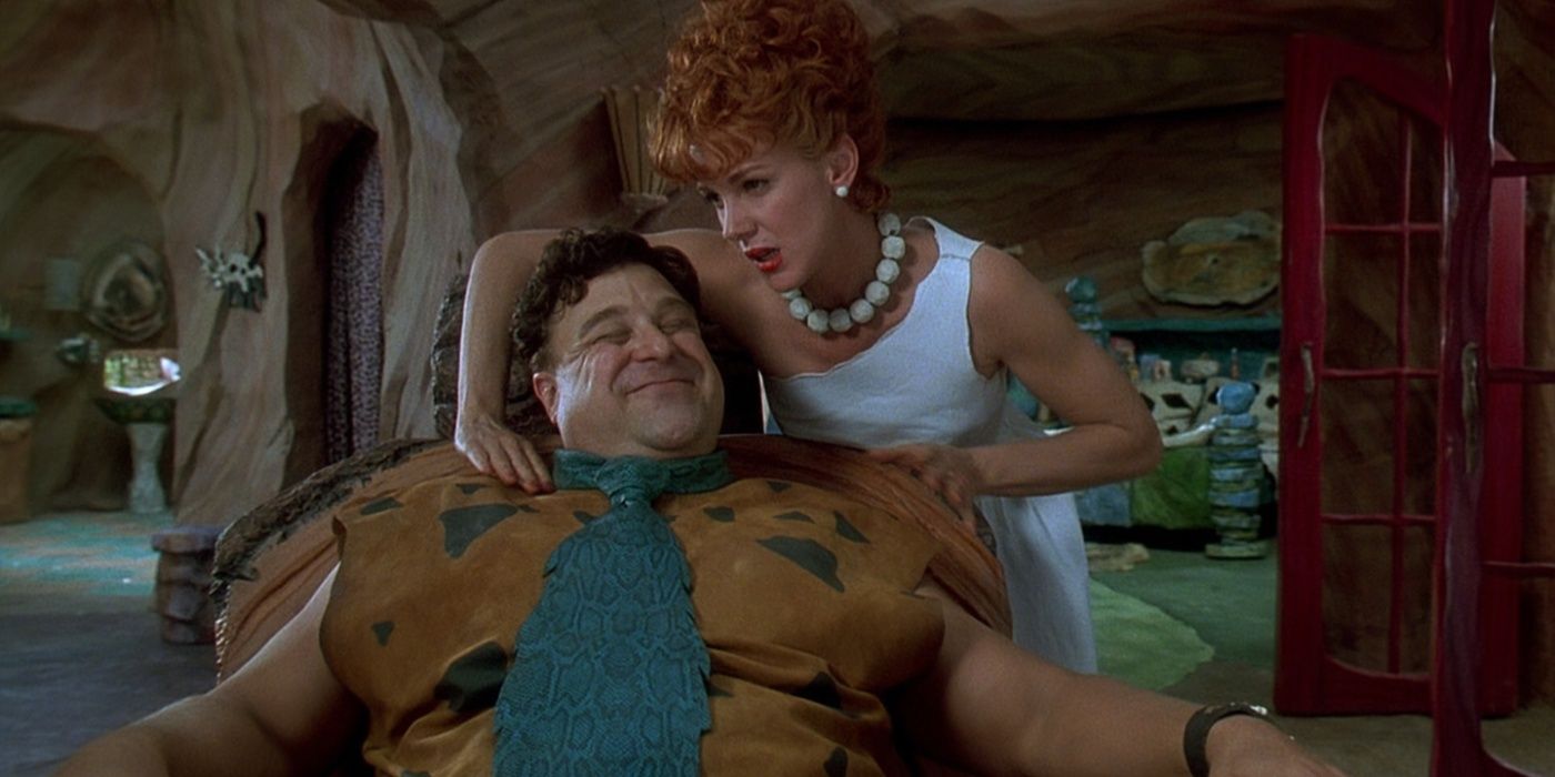 Fred (John Goodman) uśmiecha się, gdy Wilma (Elizabeth Perkins) masuje mu ramiona w „Flintstonowie”