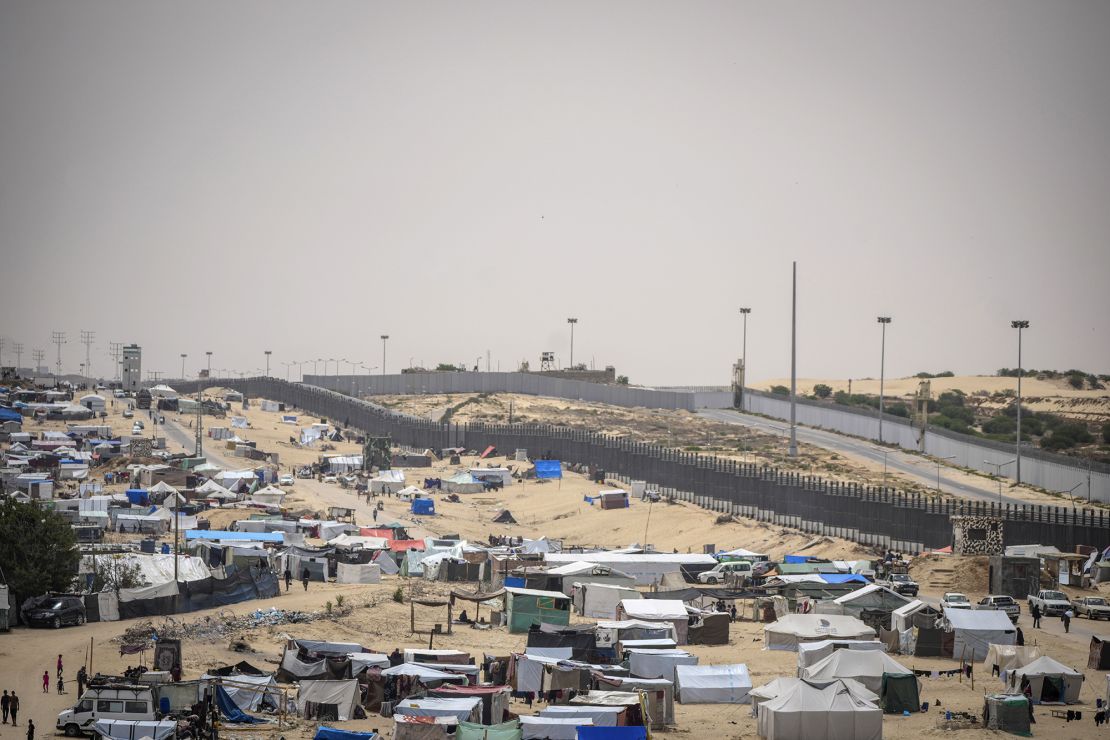 Palestyńczycy wysiedleni w wyniku izraelskiej ofensywy powietrznej i lądowej w Strefie Gazy przechodzą przez prowizoryczny obóz namiotowy w Rafah na granicy z Egiptem, w Gazie, 10 maja.