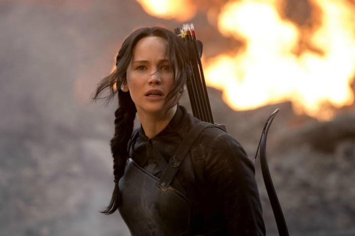 Jennifer Lawrence stoi i patrzy za siebie ogniem w Igrzyskach Śmierci.