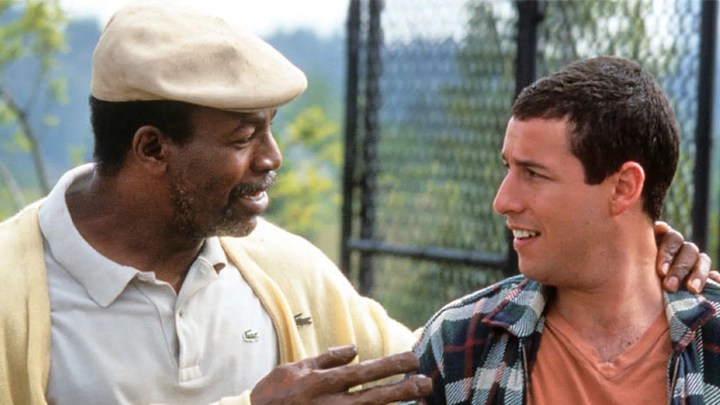 Carl Weathers jako Chubbs obejmujący Adama Sandlera jako Happy Gilmore; obaj mężczyźni patrzą na siebie w scenie z filmu Happy Gilmore.