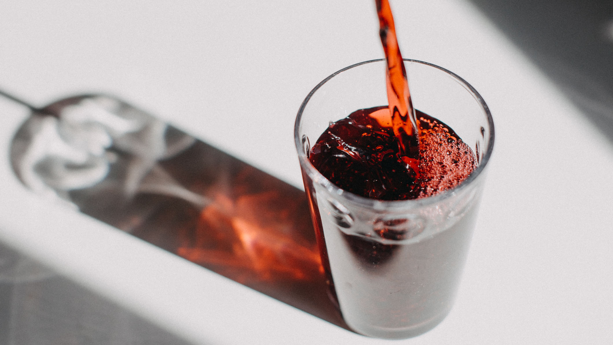 Tartowy sok wiśniowy wlewa się do przezroczystej szklanki