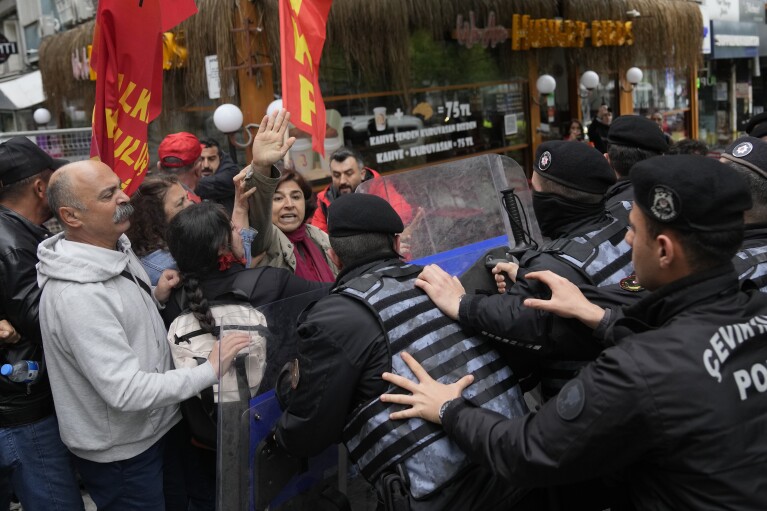 Członkowie związku szarpią się z tureckimi policjantami podczas marszu podczas obchodów Święta Pracy w Stambule, Turcja, środa, 1 maja 2024 r. Policja w Stambule zatrzymała dziesiątki osób, które próbowały dotrzeć na główny plac miasta, Taksim, wbrew rządowemu zakazowi z okazji obchodów Święta Pracy 1 maja w charakterystycznym miejscu.  (AP Photo/Khalil Hamra)