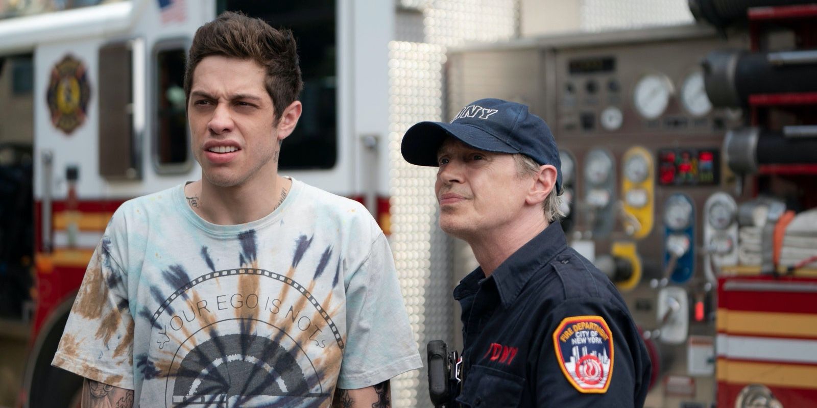 Pete Davidson i Steve Buscemi stoją razem w pobliżu wozu strażackiego w filmie Król Staten Island