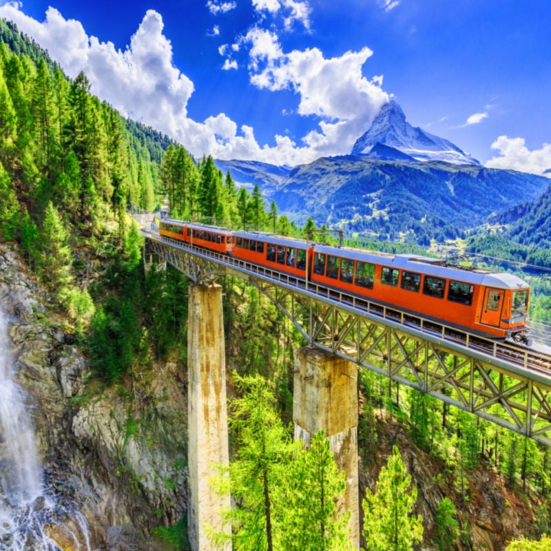 Zermatt, Szwajcaria.  Gornergrat pociąg turystyczny z wodospadem, mostem i Matterhornem.  Region Wallis