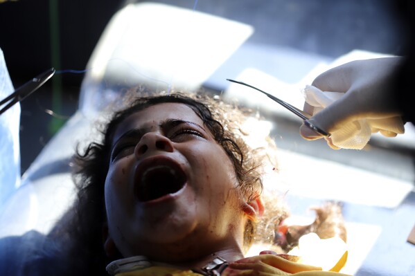 Palestyńscy lekarze zajmują się dziewczynką ranną podczas izraelskiego bombardowania Strefy Gazy w szpitalu kuwejckim w obozie dla uchodźców Rafah w południowej Gazie, wtorek, 7 maja 2024 r. (AP Photo/Ramez Habboub)