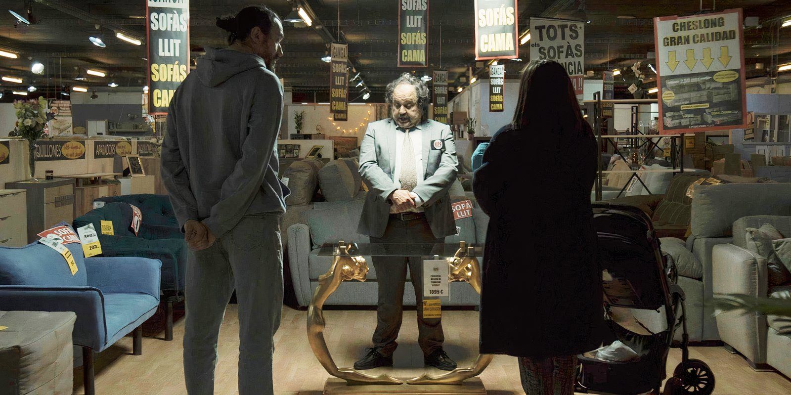 para stojąca na środku sklepu meblowego, tyłem do kamery, twarzą do sprzedawcy patrzącego na ozdobny stolik kawowy w The Coffee Table