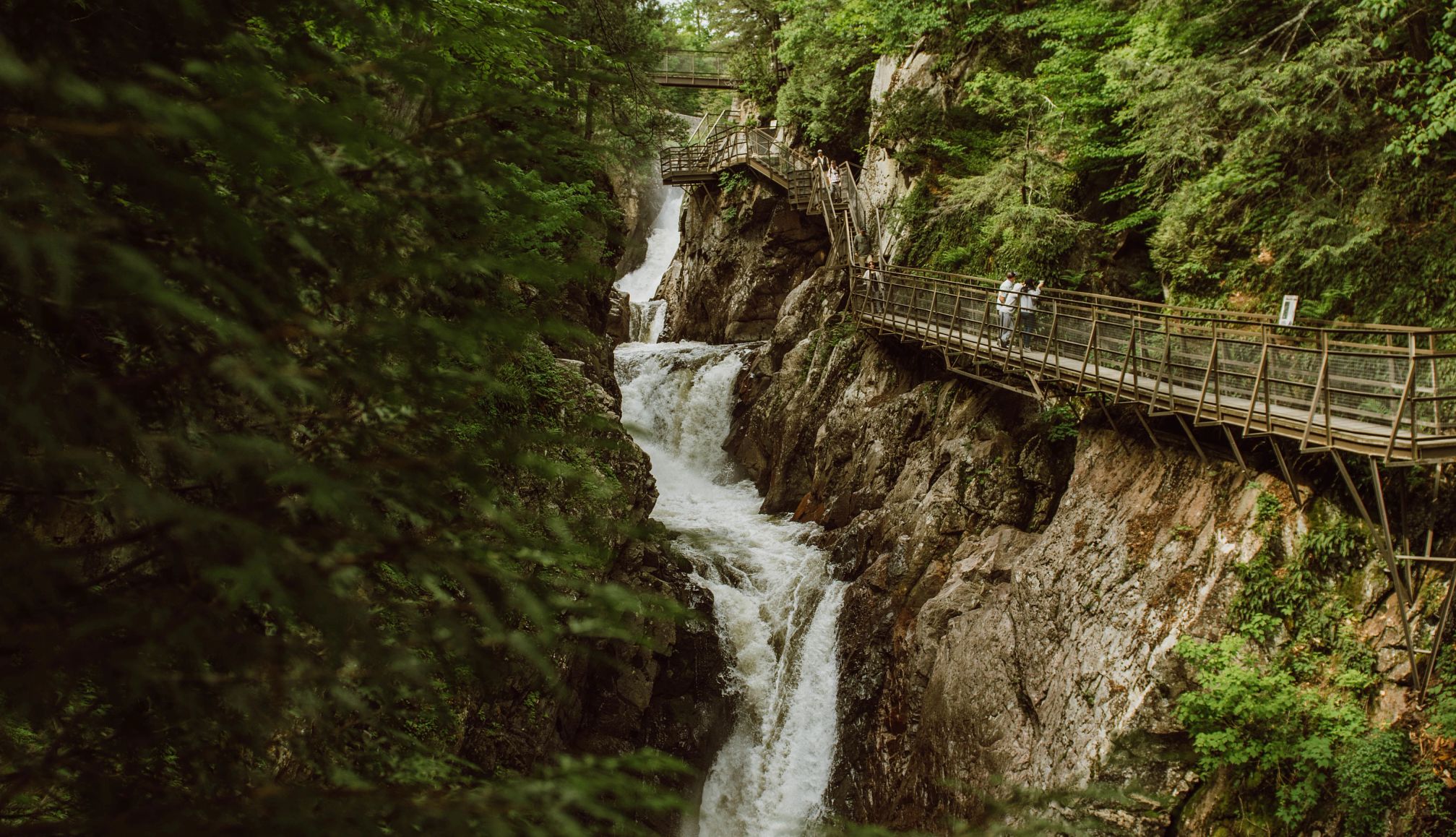 ludzie spacerują chodnikiem w wąwozie High Falls w Lake Placid w stanie Nowy Jork