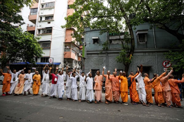 Członkowie Międzynarodowego Towarzystwa Świadomości Kryszny czekają w kolejce, aby oddać swój głos przed lokalem wyborczym podczas siódmej i ostatniej fazy wyborów powszechnych, w Kalkucie w Indiach, sobota, 1 czerwca 2024 r. (AP Photo/Bikas Das)