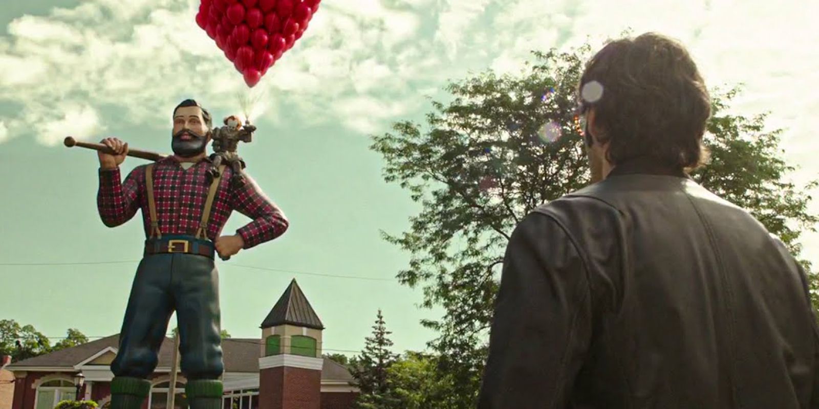 Richie spogląda na Pennywise’a, który trzyma balony, siedząc na pomniku Paula Bunyona. Rozdział drugi