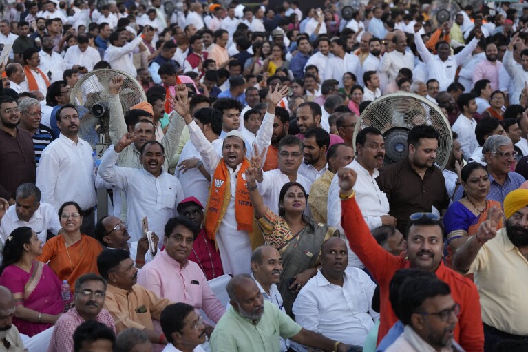 Zaproszeni wykrzykują hasła podczas ceremonii zaprzysiężenia Narendry Modiego na premiera Indii w pałacu prezydenckim w New Delhi w Indiach, niedziela, 9 czerwca 2024 r. 73-letni przywódca jest dopiero drugim premierem Indii, który utrzymał władzę trzeci termin.  (AP Photo/Manish Swarup)