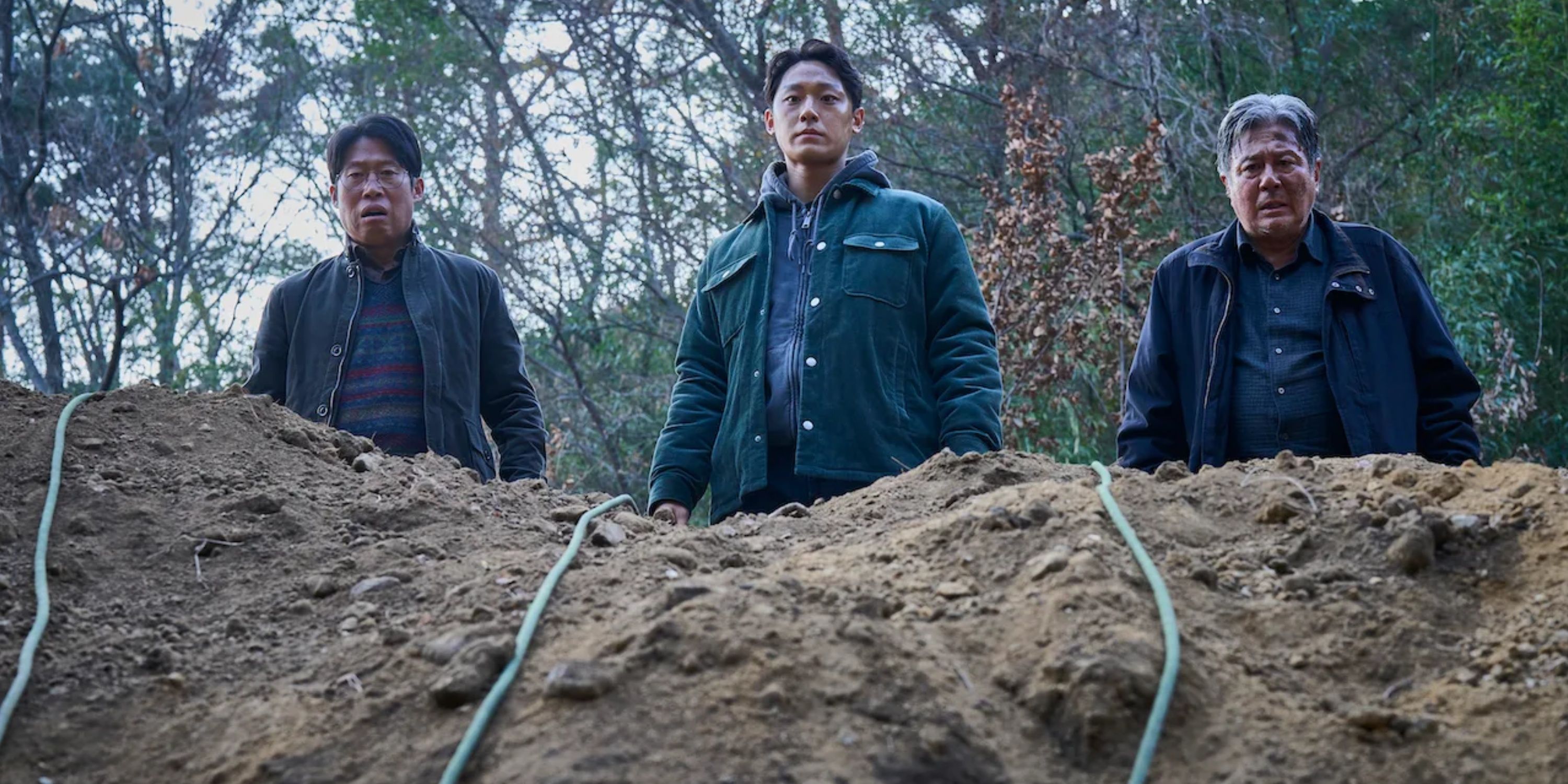 Trzej mężczyźni zaglądają do grobu podczas wydarzeń z Exhumy (2024)