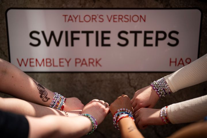 Fani Taylor Swift pozują z bransoletkami przed zdjęciem "Szybkie kroki", na zlecenie burmistrza Londynu Sadiqa Khana, przed pierwszym londyńskim koncertem w ramach Eras Tour w piątek, 21 czerwca 2024 r. w Londynie.  (Zdjęcie: Scott A Garfitt/Invision/AP)