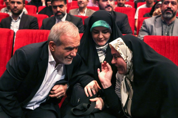 Masoud Pezeshkian siedzący obok córki i słuchający rozmawiającej z nim kobiety