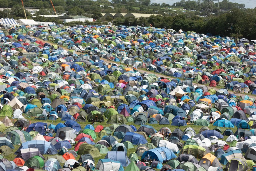 Ludzie chodzą wokół namiotów rozstawionych na głównych polach kempingowych.