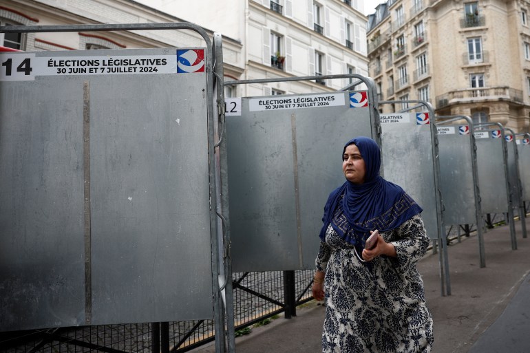 Kobieta przechodzi obok komisji wyborczych ustawionych przed wyborami parlamentarnymi we Francji 30 czerwca i 7 lipca w Paryżu, Francja, 19 czerwca 2024 r. REUTERS/Benoit Tessier