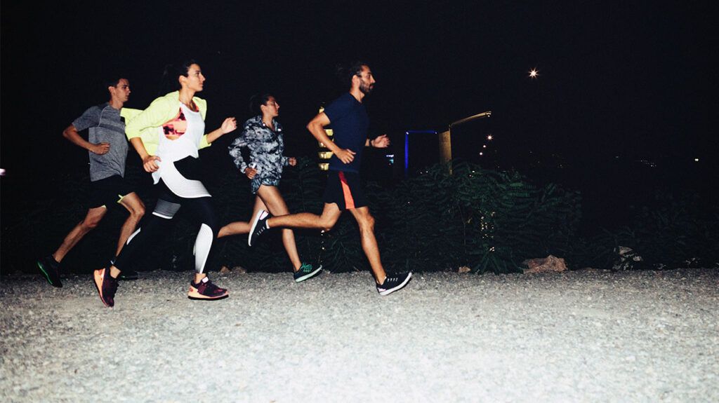 grupa ludzi biegających wieczorem