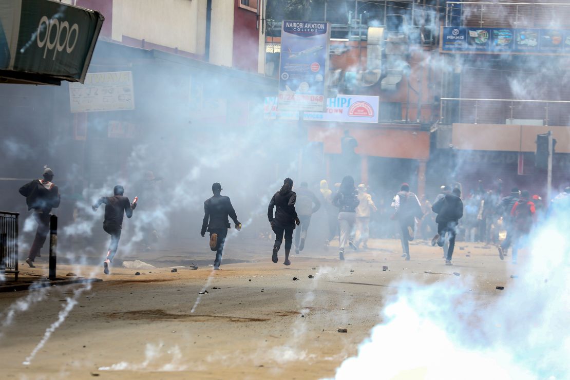 Demonstranci reagują, gdy policja strzela gazem łzawiącym, aby ich rozproszyć podczas wznowionego protestu 27 czerwca 2024 r.