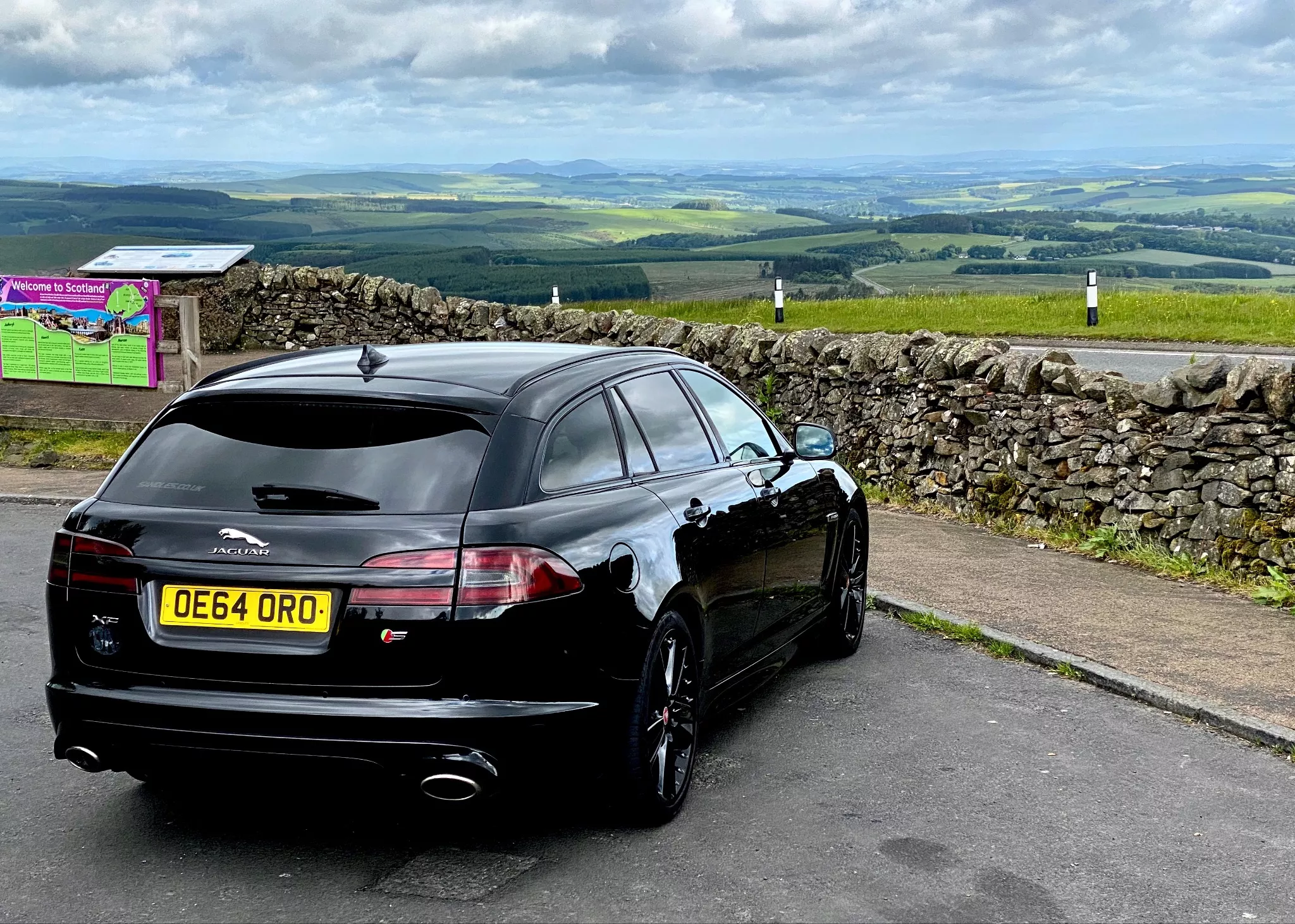 Samochód Jaguar zaparkowany na granicy Anglii i Szkocji w letni poranek 