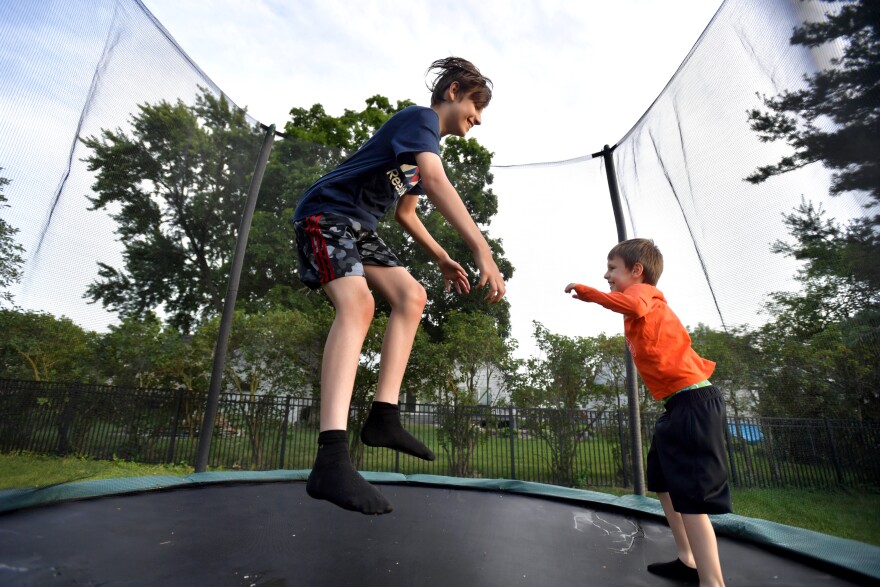 Vitalik Vakhutko (13 l.) i jego 6-letni brat Evgeny bawią się na trampolinie na rodzinnym podwórku.