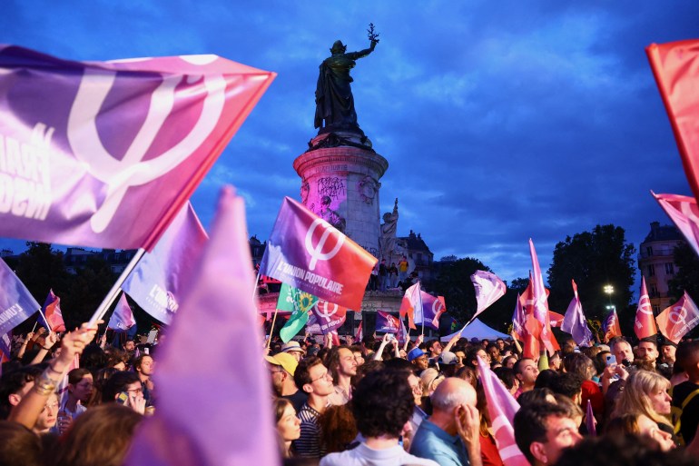 Wiec poparcia dla lewicowego Nowego Frontu Ludowego – NFP i przeciwko RN w Paryżu.  Ludzie machają flagami i banerami NFP
