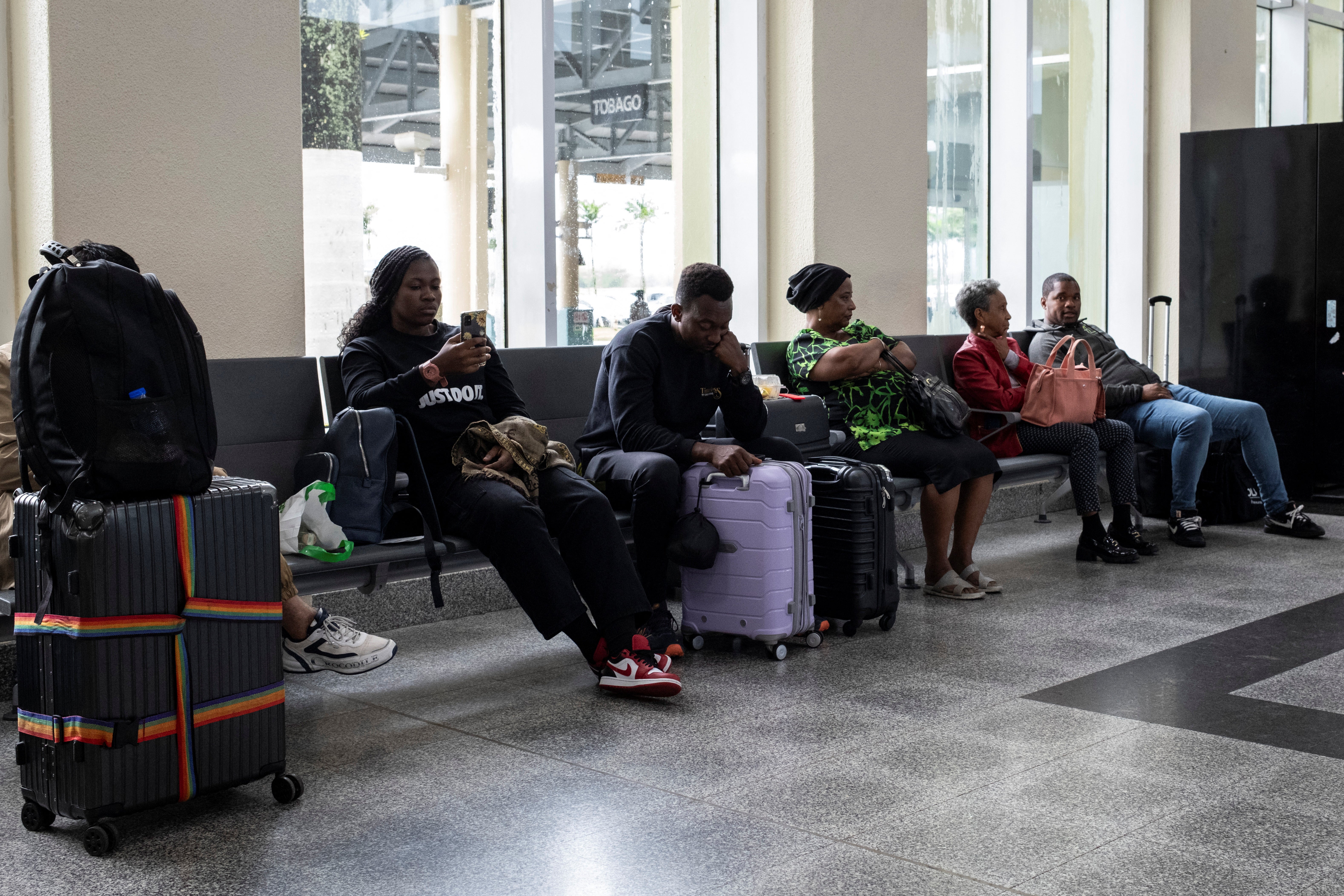 Podróżni czekają na lotnisku międzynarodowym w Piarco, ponieważ loty są opóźnione i odwołane z powodu huraganu Beryl