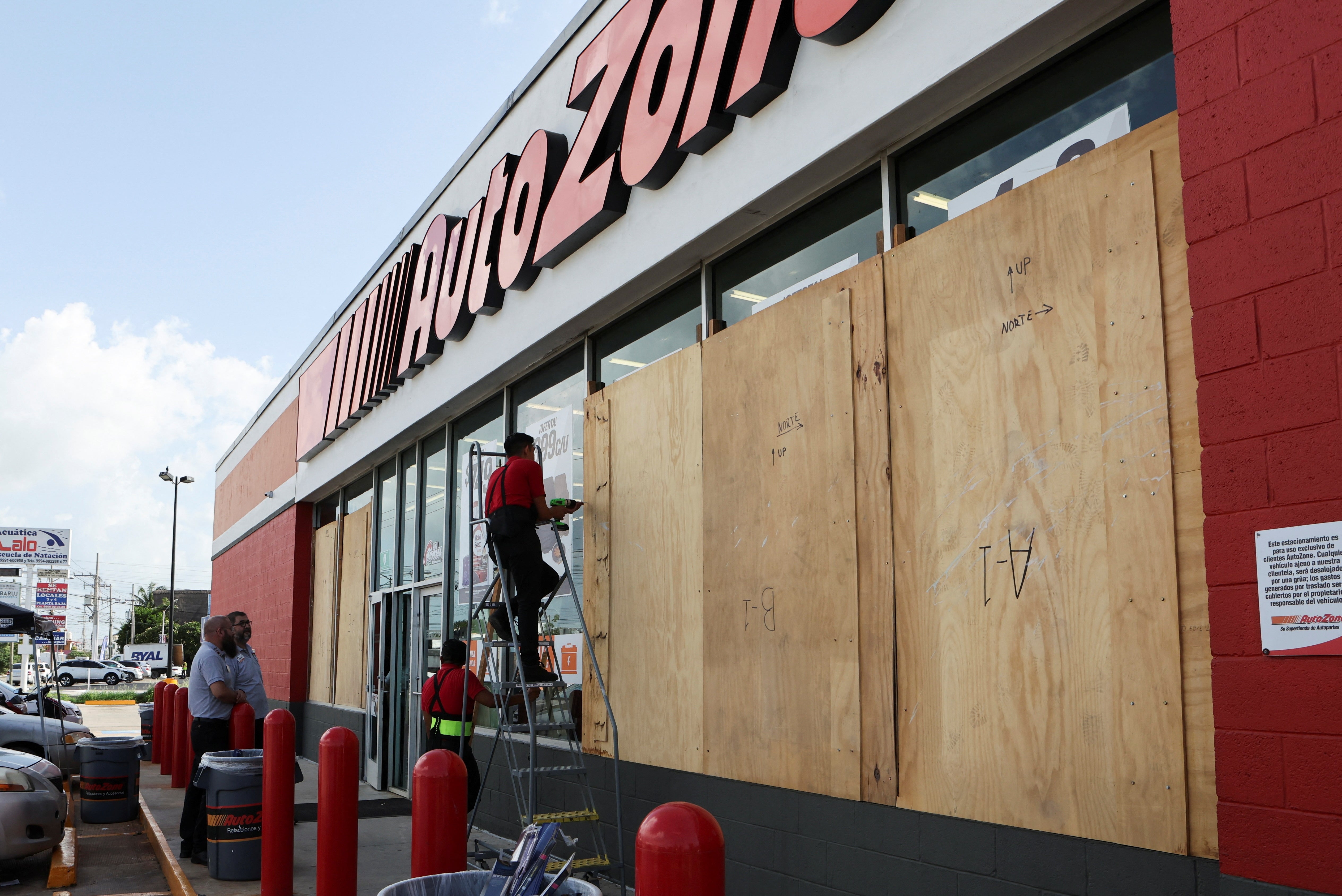 Pracownicy zamykają przedsiębiorstwo deskami, aby uniknąć szkód przed huraganem Beryl w Meridzie w Meksyku 3 lipca