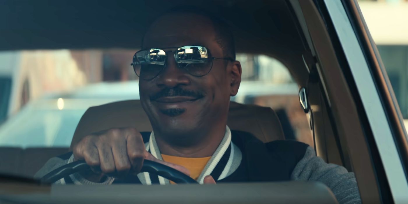 Eddie Murphy jako Axel Foley, w okularach przeciwsłonecznych i uśmiechający się podczas jazdy w filmie Gliniarz z Beverly Hills: Axel F.