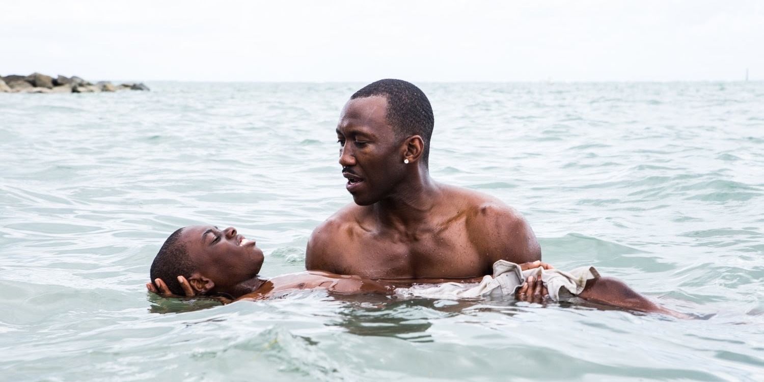 Mahershala Ali trzymający Alexa Hibberta w wodzie, kadr z filmu Moonlight. 